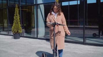 een jong meisje huurt elektrisch scooter gebruik makend van mobiel telefoon app. toerist telefoon sollicitatie. modern gadgets voor jong mensen en bedrijf mensen. ecologisch stad vervoer video