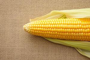 AI generated Isolated corn cob on textured brown sackcloth background, side view photo