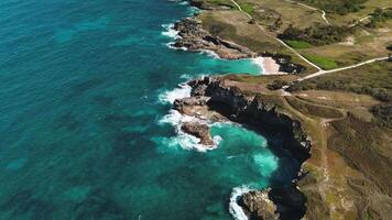 Area view of Colorful waters of ocean, swirl around rocky and scenic coastline video