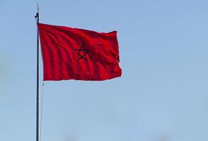 el bandera de Marruecos revoloteando en azul cielo antecedentes foto