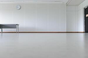 Empty room modern interior - floor with soundproof wall, door, clock and table photo