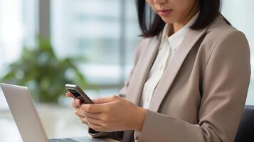 ai generado un asiático mujer de negocios expertamente maniobras su teléfono inteligente en su oficina ambiente, su enfocado expresión reflejando intenso concentración como ella se involucra en varios en línea trabajo Tareas foto