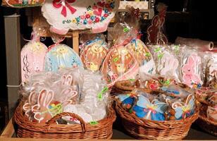 Traditional Easter gingerbread cookies in the shape of a colorful egg with drawings of a hare and chickens are sold at a market photo