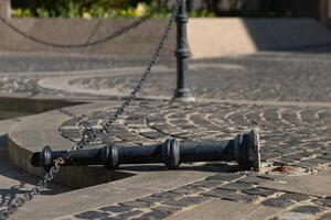 an overturned metal pole with chain photo