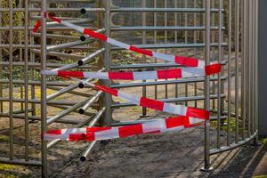 metal gate with red and white tape on it photo