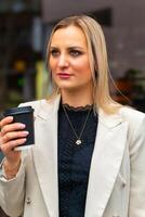 woman in a white jacket holding a coffee cup photo