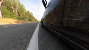 el coche es Moviente a lo largo el carretera. disparo desde un bajo punto y distorsionado perspectiva video