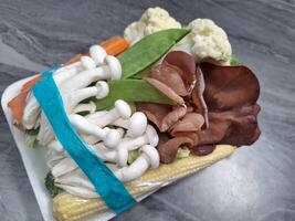 Image of mushrooms and vegetables on a marble table photo