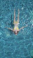 Caucasian woman swimming on the back in the pool in slow motion. video