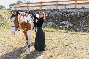 contento de moda joven mujer posando con un caballo en el playa foto