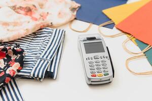 Close up of hand using credit card swiping machine to pay. credit card payment through a shopping terminal. Credit card payment for new clothing collection photo