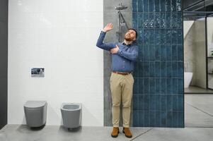 selecciona un ducha grifo. hombre elige un productos en un sanitario mercancía Tienda foto