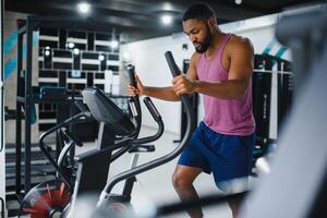 Weight training African doing bodybuilding in gym. photo