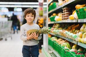 pretty boy with pineapple in supermarket photo