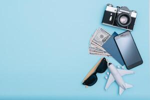 Preparation for Traveling concept, watch, airplane, money, passport, pencils, book, Photo frame, eyeglass on blue background with copy space.