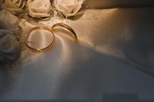 Beautiful wedding gold rings on dark background photo