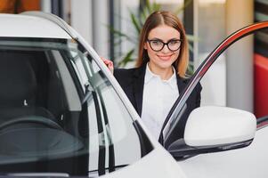 business woman in auto salon. concept of female driver photo