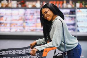 African american woman at supermarket with shopping cart photo