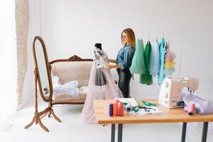 Can't make any mistake. Female fashion designer works on the new clothes in the workshop. photo