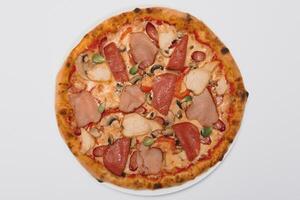 whole pizza with different meat toppings photo
