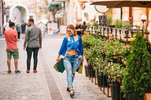 Smiling young woman posing with a handful of shopping bags. Shopping concept. photo