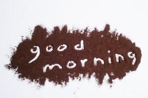 Wake up word written on ground coffee layer, white background photo