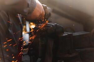 sawing metal. sparks frying over the working table during metal grinding photo