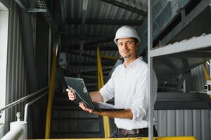 happy male industrial technician inside a factory photo