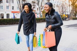 young black women going shopping. African American girls with shopping bags go shopping photo