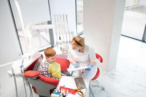 Female dentist and child in a dentist office photo