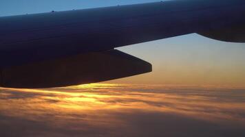 des nuages et magnifique lever du soleil. vue de le fenêtre de un avion aile, des nuages et une magnifique lever du soleil. video