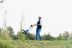 padre y hijo tener divertido juntos en naturaleza. padre y hijo jugando. personas teniendo divertido al aire libre. concepto de simpático familia. foto