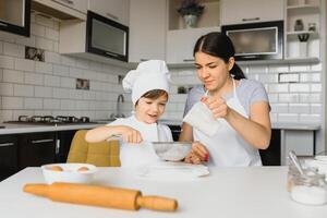 Son and mother preparing dough together photo