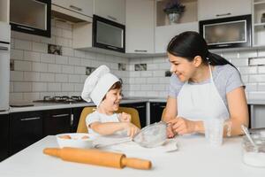 Son and mother preparing dough together photo
