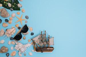 Flat lay. Top view. Frame of shells of various kinds on a blue background. Seashells and starfish and ship on a pastel background. Vacation concept. travel concept. with copy space photo