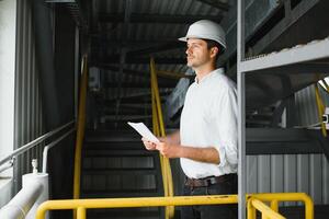 happy male industrial technician inside a factory photo