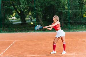 Woman in sportswear plays tennis at competition photo