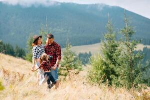 Young family with child resting on a mountain photo