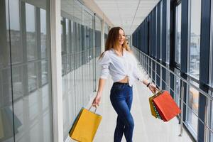 Fashion Shopping Girl Portrait. Beauty Woman with Shopping Bags in Shopping Mall. Shopper. Sales. Shopping Center photo