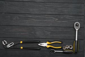 Set of assorted work carpentry and locksmith tools on a dark wooden background with copy space photo