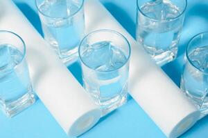 Water filters. Carbon cartridges and a glasses on a blue background. Household filtration system. photo