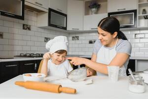 hijo y madre preparando masa juntos foto