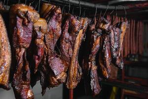 Smoked traditional smoked meat. A composition of smoked cold cuts on a black background. photo