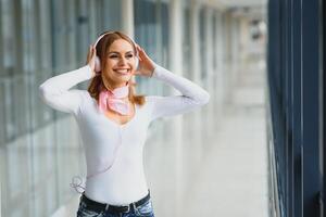 elegante niña escuchando a música rosado auriculares foto