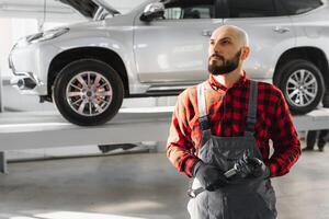 Mechanic working and holding wrench of service order for maintaining car at the repair shop photo