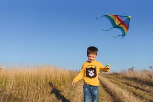 Little boy with kite flying over his head photo