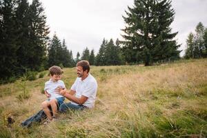 Happy father and little child are walking in the mountains. Father's Day. vacation in the national park photo