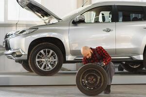 Mechanic holding a tire tire at the repair garage. replacement of winter and summer tires. photo