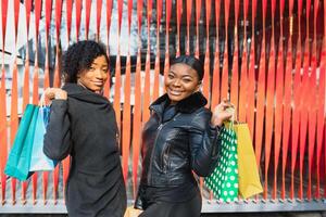 young black women going shopping. African American girls with shopping bags go shopping photo