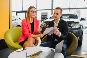 business woman buys a car at a car dealership. Concept of happy business people photo